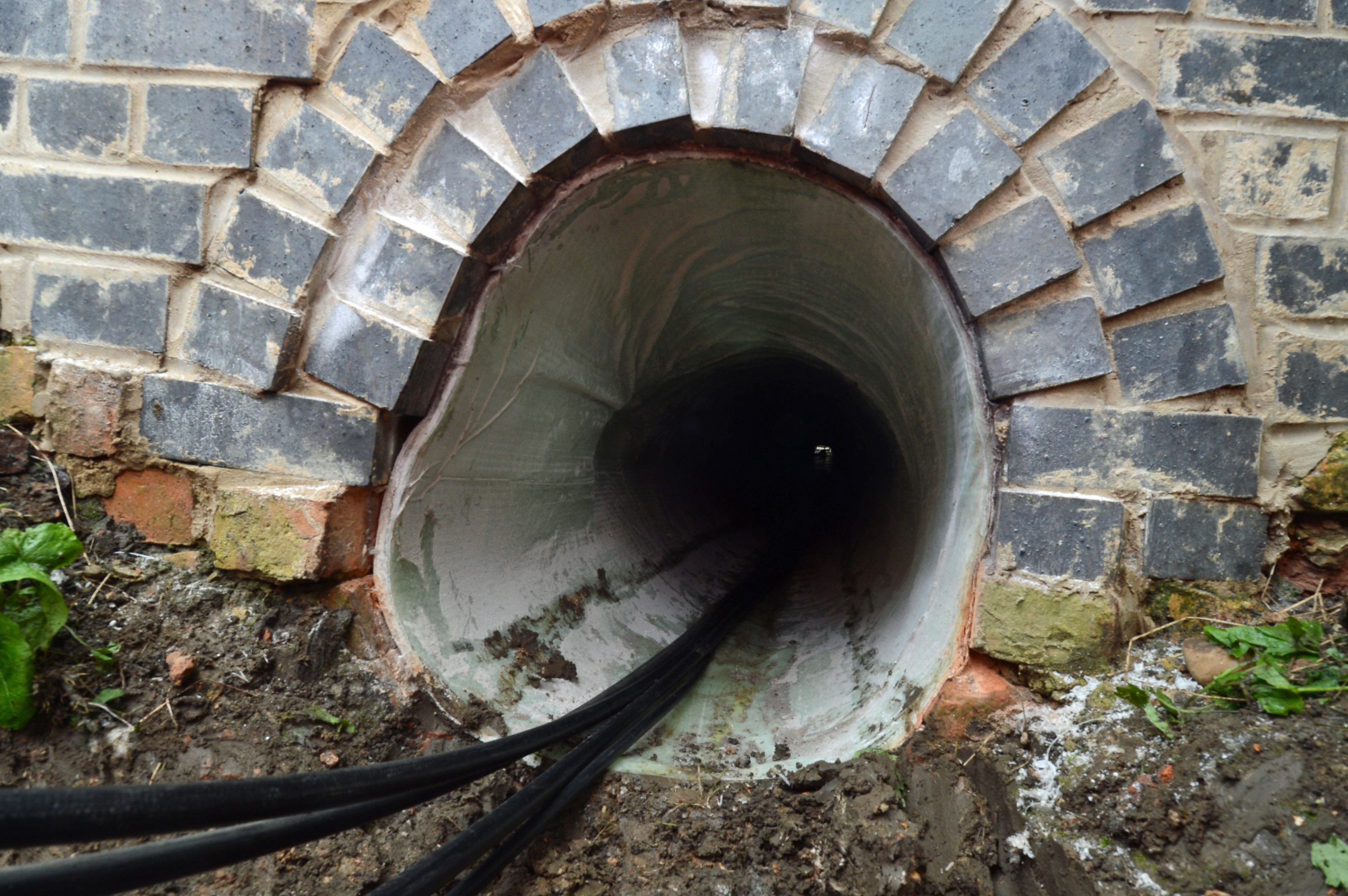 One of the problems with railway engineering is that the public don’t always get to see (and thus appreciate) where the money is spent on modernising & repairing our railways. Here’s a case in point... In 2013 a series of culverts under the embankment near Stow Park were religned. These hadn’t been touched since the line was built in 1882. In some of them several courses of bricks has collapsed & needed to be replaced to prevent the danger of the embankment collapsing. In this health & safety conscious age there’s no question of sending men into such a confined space, so a more modern method was used to reline the culvert. Once debris had been removed a flexible liner was pulled through. Once in place, it was sealed at either end then inflated by compressed air in order that it pressed against the brickwork. Once this was done, a trolley equipped with UV lamps was run through the liner, baking it. The liner material then sets like concrete. It’s not a cheap fix. Depending on the size of the liner they can cost tens of thousands of pounds, but they’re guaranteed for over 60 years. Here’s one of the culverts after the work had been completed.