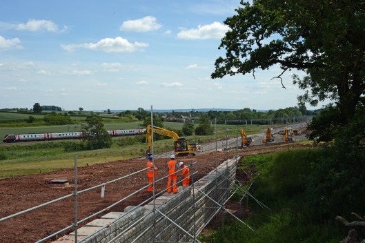 Building a retaining wall to protect an old Marl pit which is being preserved. The area above at the top of the embankment is being levelled as it will contain a drainage channel. meanwhile, in the background, Pendolinos pass on the existing WCML.