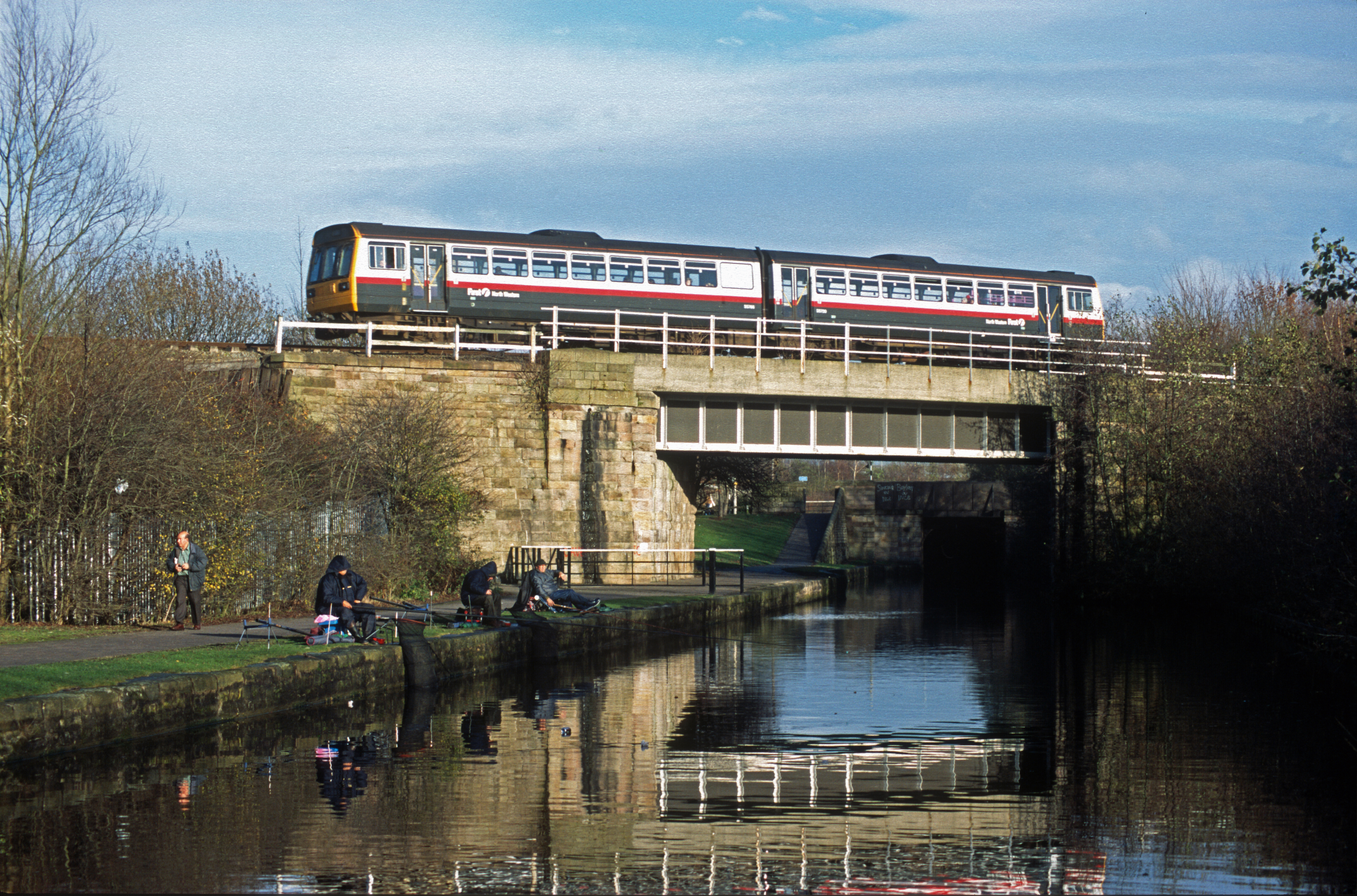 11551. FNW Class 142 passes over the Leeds and Liverpool canal. Wigan. 28.11.2002
