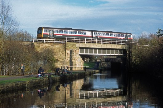 11551. FNW Class 142 passes over the Leeds and Liverpool canal. Wigan. 28.11.2002